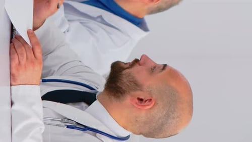 Doctors Discussing Patient Notes in Hospital Setting