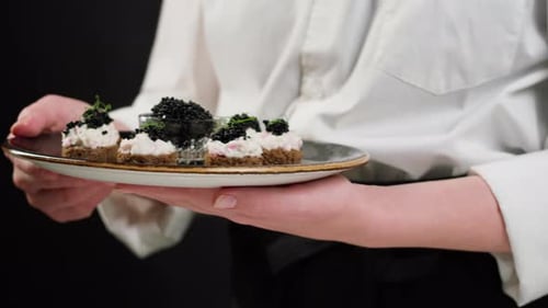 Appetizers with Black Caviar Held by Server