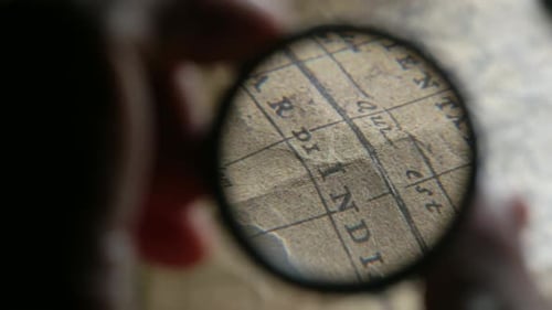 Examining Antique Map with a Magnifying Glass