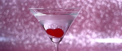 Rotes Gummiherz mit sprudelnden Blasen im Glas