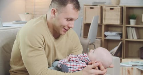Man Holding Baby, Bonding Moment Indoors