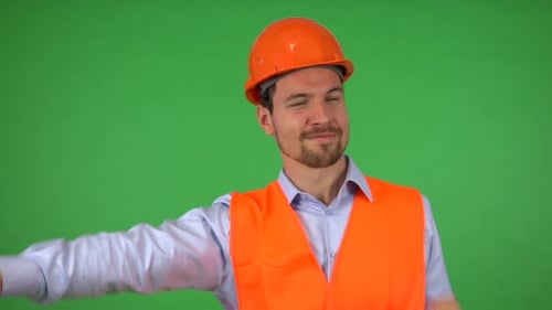 A Young Handsome Construction Worker Dances and Smiles at the Camera - Green Screen Studio