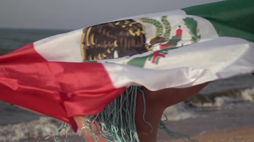 Woman Walks on Beach with Mexican Flag