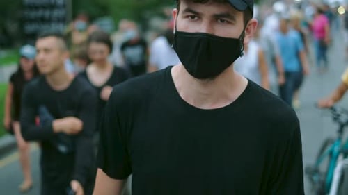 Young Adult Walking in Crowd Wearing Face Mask