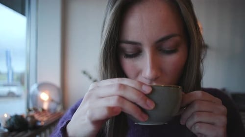 Woman Enjoying Coffee in Cozy Setting