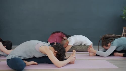 Adults Stretching in a Yoga Class