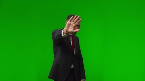 Portrait of Unhappy Business Man Worker Standing Over Isolated Green Background Puts His Palms in