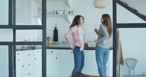 Two Women Friends Dancing in a Kitchen