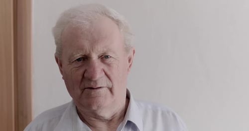 Close Portrait of Senior Man with Bright Eyes Looking and Smiling at Camera