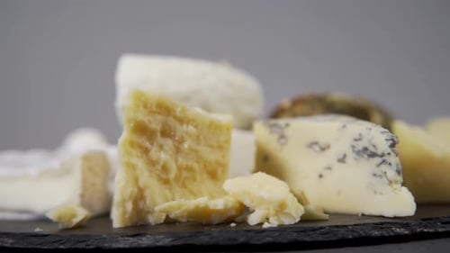 Panorama of Various Sorts of Delicious French Cheeses Laying on the Black Board