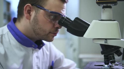 Scientist Viewing Sample Through a Microscope in Lab