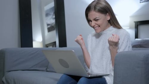 Excited Woman Celebrating Success With Laptop Computer