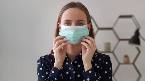 Woman Puts on a Surgical Face Mask