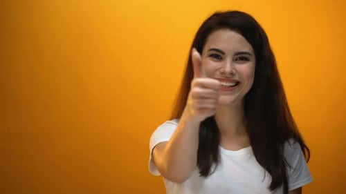 Smiling Brunette Woman Gives Thumbs Up