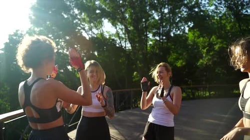 High Five. Pretty Sportswomen Standing in Park and Giving High Five.