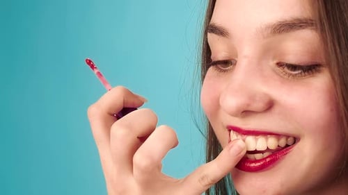 Woman Applies Bright Red Lipstick with Brush