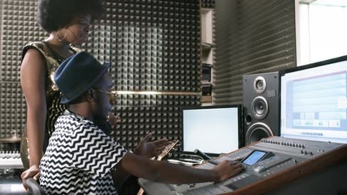 Woman and Sound Engineer Working in Recording Studio
