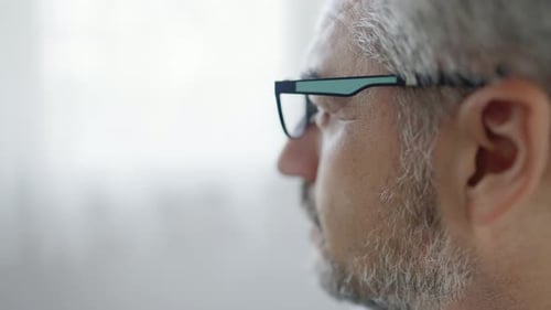 Close up shot slow motion of old man looking out of the windows