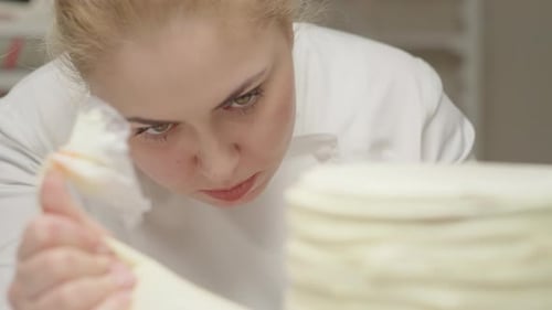 Close Up Pf Chef Decorating Rotating Cake Using Pastry Bag with Cream