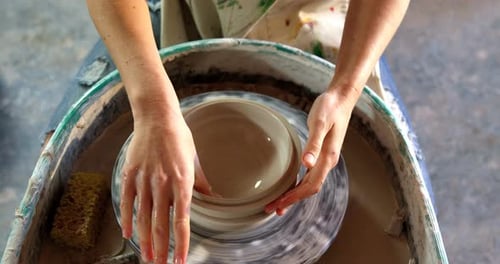 Potter Shaping Clay Bowl on Pottery Wheel