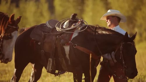 Un grupo de vaqueros se ensillan y se preparan para el paseo
