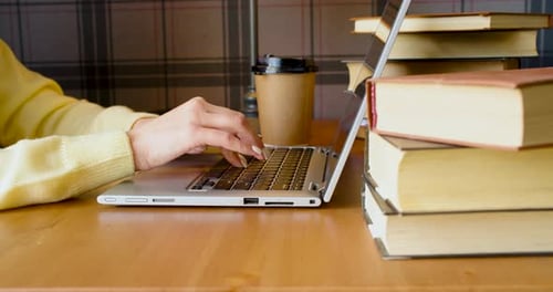 Femaale Hands During Work in Front of a Laptop Monitor in a Library
