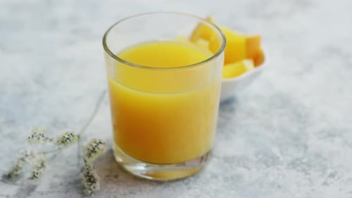 Close Up of Orange Juice and Cut Fruit