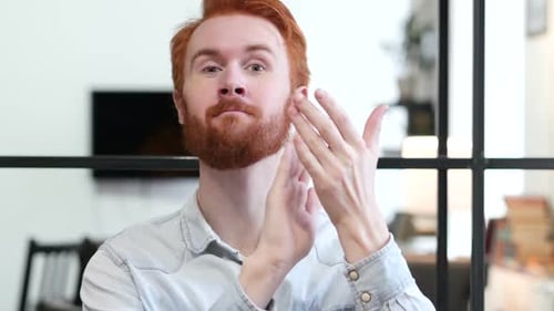 Red-Haired Man Clapping in Office