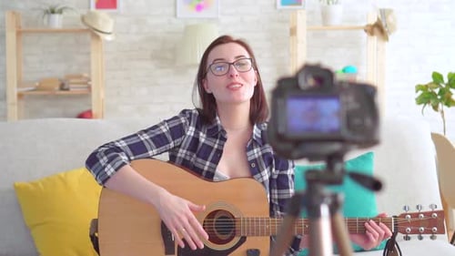 Young Woman Plays Guitar and Records Video