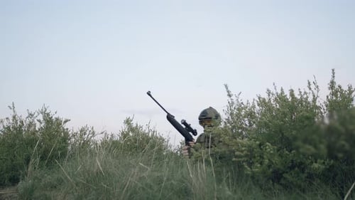 Soldier Taking Aim with Rifle in Grassy Field