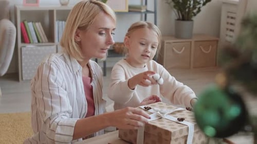 Woman and Girl Decorate Present Together at Home