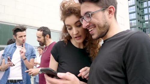 Group of friends using smartphone in city