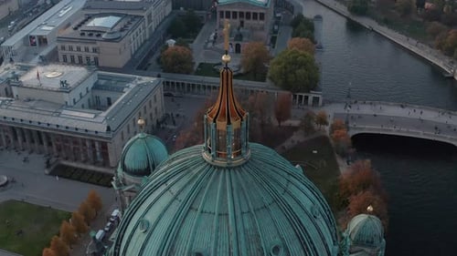 AERIAL: Circling Berlin Cathedral Top with Golden Cross and Streets in Background, Germany in Fall
