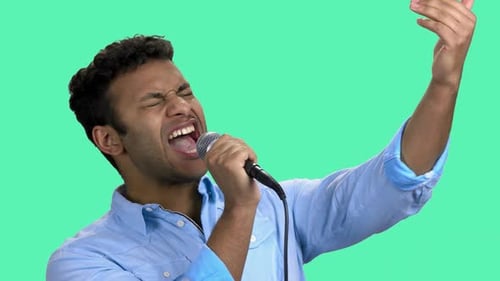 Young Adult Man Singing Passionately Into Microphone