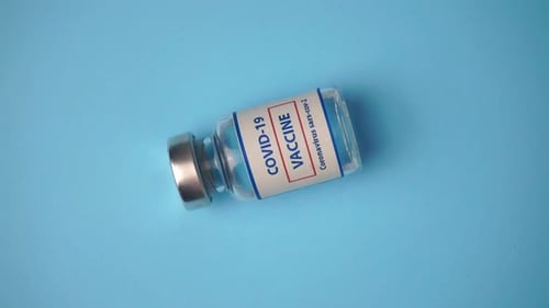 COVID-19 Vaccine Vial on Light Blue Background