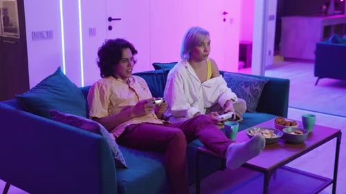 Young Adults Playing Video Games at Home at Night