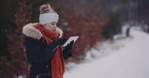 Woman Using Tablet in Winter Snow