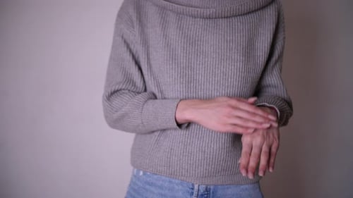 Woman Demonstrating Hand Gestures Against a Plain Background