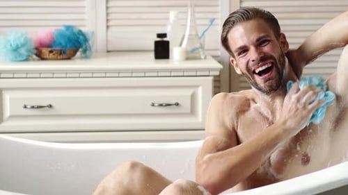 Smiling Man Relaxing in Soapy Tub