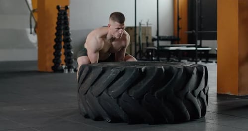 Man in Gym, Lifts and Flips a Large Tire, Muscle Training with Weights in Slow Motion, Crossfit.