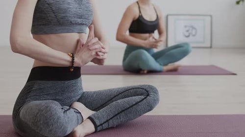 Two Women Meditating in Yoga Studio