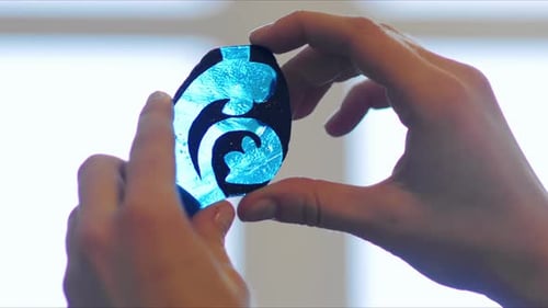 Hands Hold Abstract Art with Blue Swirls