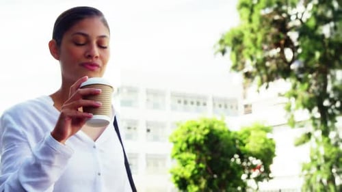 Woman sipping coffee on street