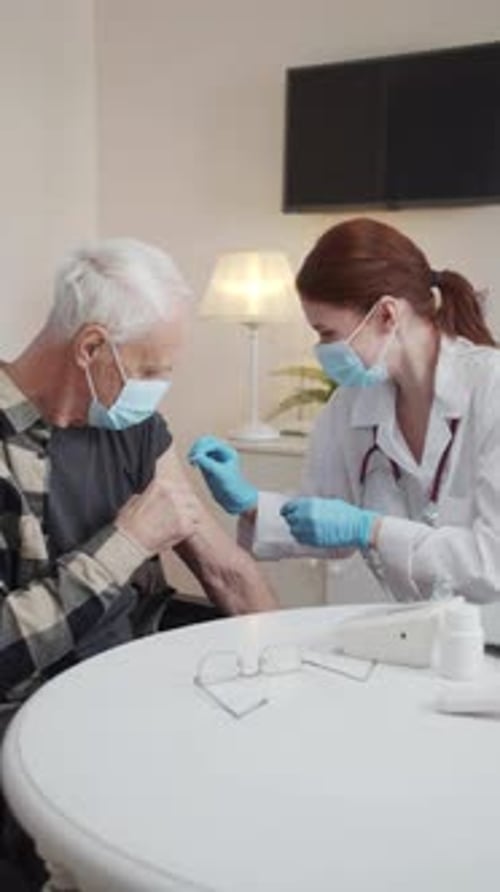 Doctor Giving Senior Man an Injection at Home