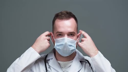 Doctor Removing Surgical Mask in Studio Setting