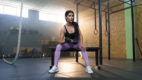 Fit Woman Training Hands Using Dumbbells in the Gym