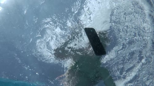Person Swimming Underwater with Mobile Phone