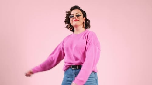 Woman Dancing in Sunglasses and Pink Sweater