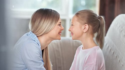 Attractive Happy Young Mother Relaxing with Little Daughter Showing Best Love Feeling at Home