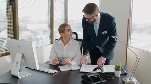Professional Man and Woman Collaborating in Office